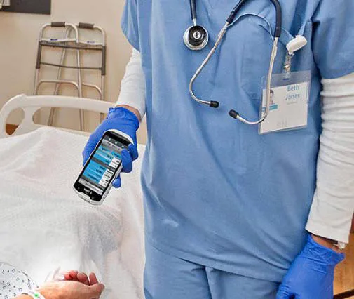 Profesional de salud usando una computadora móvil junto al paciente